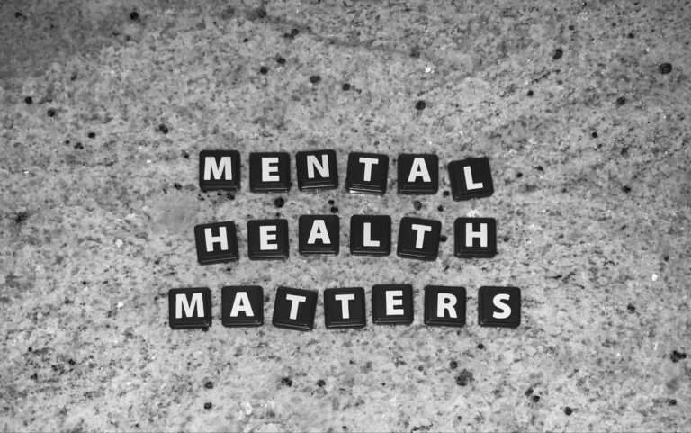 Scrabble pieces spelling “Mental Health Matters” on a granite background.