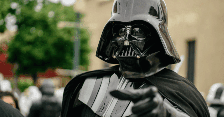 A Darth Vader cosplayer pointing at the camera.