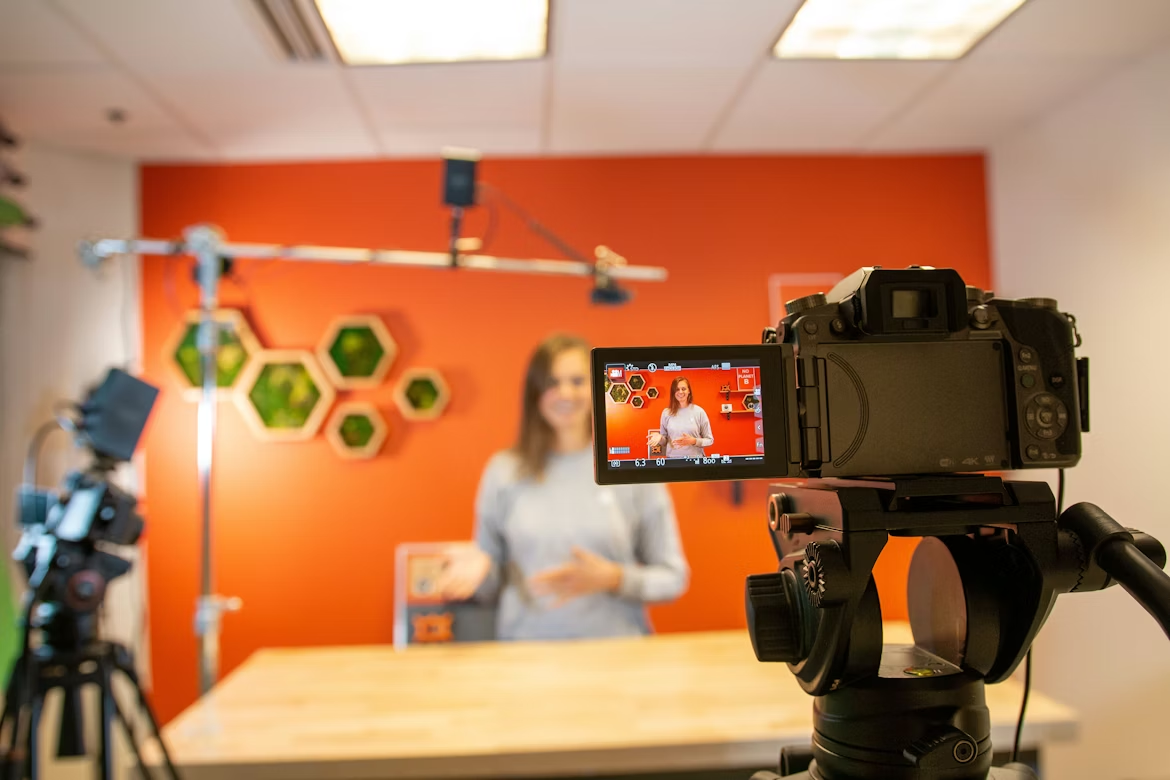 A camera filming a woman explaining something.