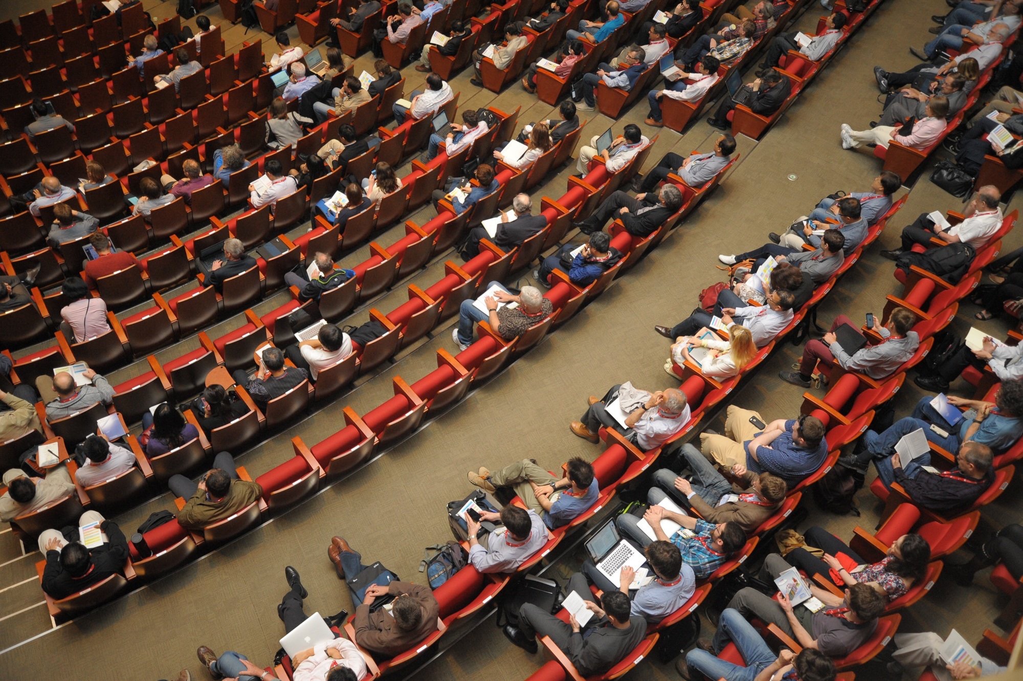 An auditorium with attendees listening to a presentation.