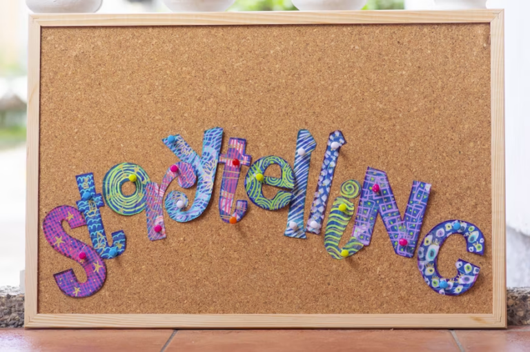 Cut-out letters making up the word storytelling pinned to a cork board.