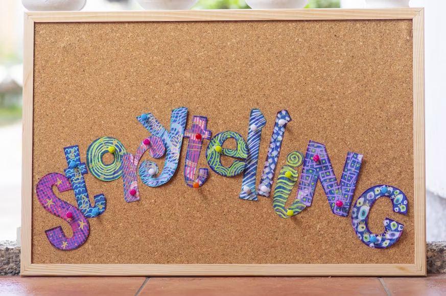 Cut-out letters making up the word storytelling pinned to a cork board.