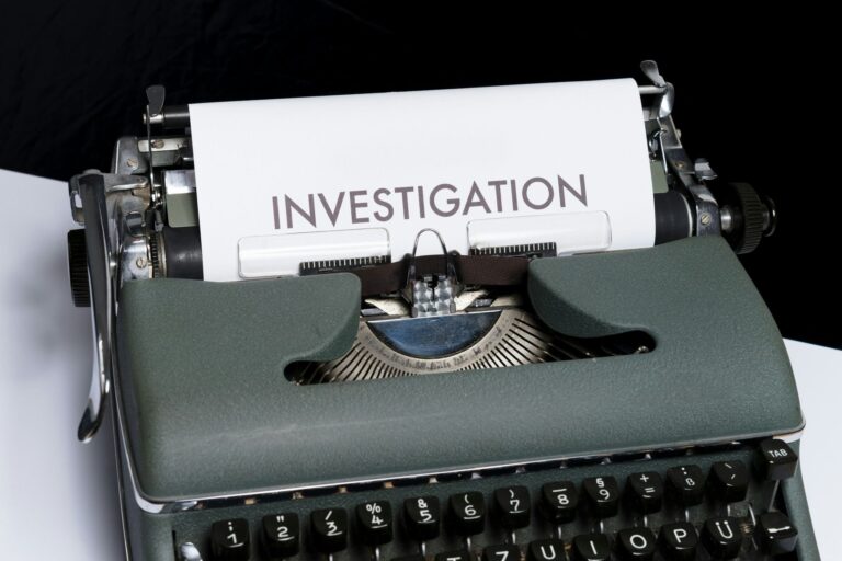 typewriter with a sheet of paper inserted into it with the inscription "Investigation"